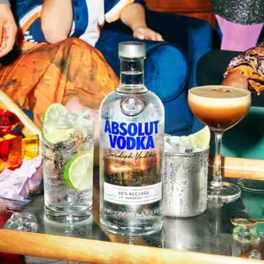 Absolut Vodka bottle with fresh cocktail ingredients on a bar table
